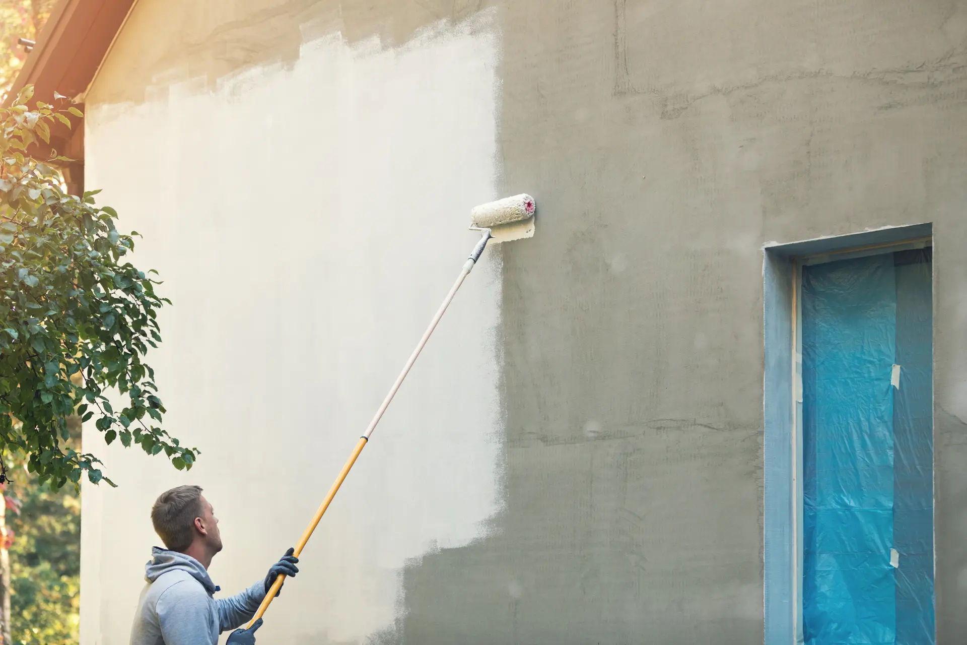 Pintor trabajando en una fachada en Molina